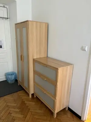 a wooden cabinet with three drawers in a room at Home in Krakow Silvio's Apartments in Kraków