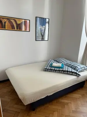 a bed in a room with two pictures on the wall at Home in Krakow Silvio's Apartments in Kraków