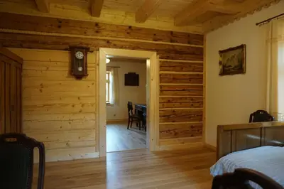 a bedroom with wooden walls and a wooden floor at Organistówka in Rabka