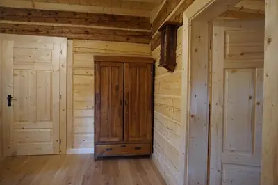 an empty room with wooden walls and doors at Organistówka in Rabka