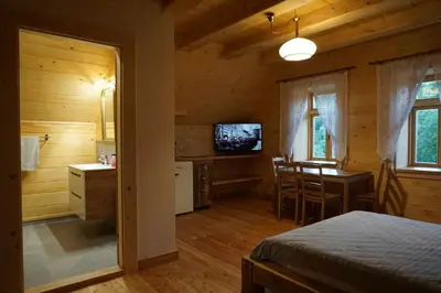 a bedroom with a bed and a kitchen and a table at Organistówka in Rabka
