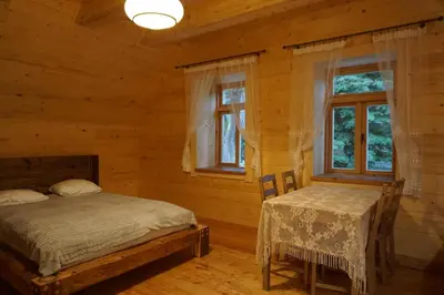 a bedroom with a bed and a table and two windows at Organistówka in Rabka