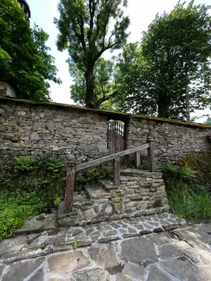 a stone wall with a wooden bench on it at Organistówka in Rabka
