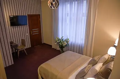a hotel room with a bed and a vase of flowers at Hotel Kazimierz II in Kraków