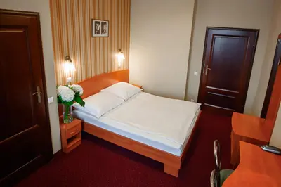 a bedroom with a bed and a vase of flowers at Hotel Kazimierz II in Kraków