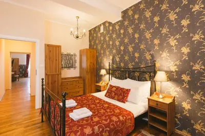 a bedroom with a bed with a floral wallpaper at Abella Suites & Apartments by Artery Hotels in Kraków