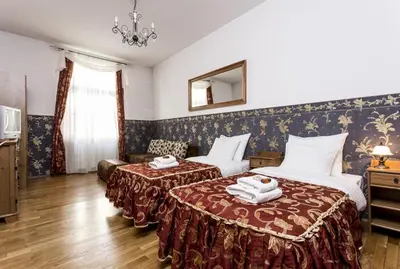 a hotel room with two beds and a mirror at Abella Suites & Apartments by Artery Hotels in Kraków