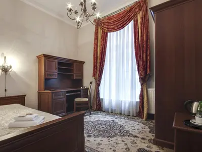 a bedroom with a bed and a desk and a window at Abella Suites & Apartments by Artery Hotels in Kraków
