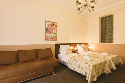 a hotel room with two beds and a couch at Abella Suites & Apartments by Artery Hotels in Kraków