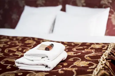 a pile of towels sitting on top of a bed at Abella Suites & Apartments by Artery Hotels in Kraków