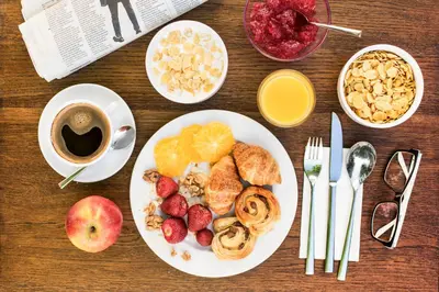 a table with a plate of breakfast foods and a cup of coffee at Abella Suites & Apartments by Artery Hotels in Kraków