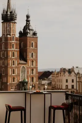 a bedroom with a bed and a desk and chairs at Hotel Stary in Kraków