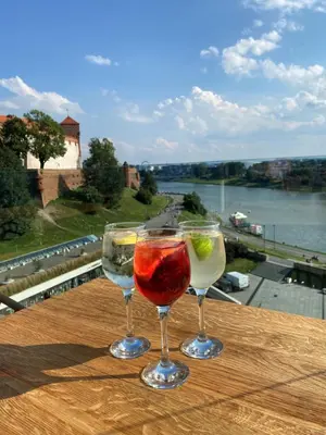 two wine glasses sitting on top of a wooden table at Hotel Pod Wawelem in Kraków