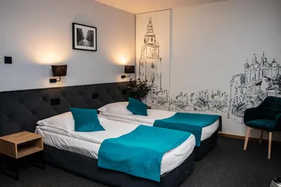 a hotel room with a bed and a chair at Hotel Pod Wawelem in Kraków