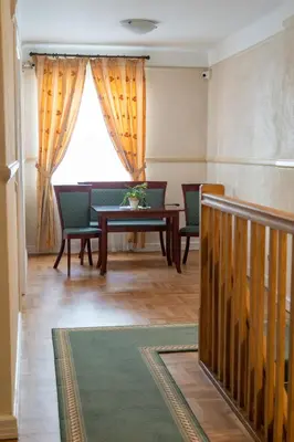 a living room with a table and chairs and a window at Aparthotel Karmel in Kraków