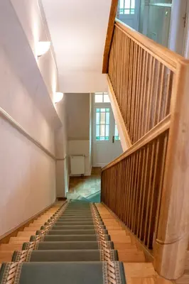 a stairway in a building with wooden stairs at Aparthotel Karmel in Kraków