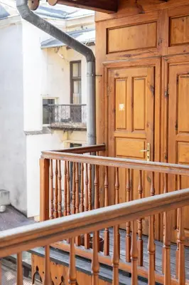 a wooden staircase in a building with a wooden door at Aparthotel Karmel in Kraków