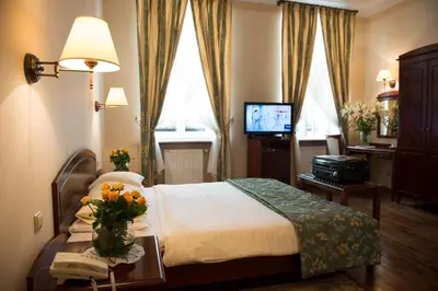 a hotel room with a bed and a television at Aparthotel Karmel in Kraków