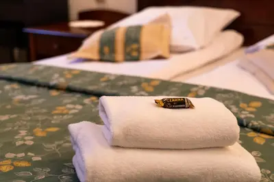 a pile of towels sitting on top of a bed at Aparthotel Karmel in Kraków