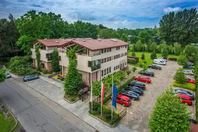 an aerial view of a building with cars parked in a parking lot at Farmona Hotel Business & SPA in Kraków
