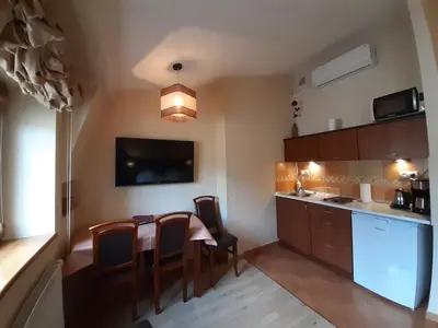 a kitchen with a table and chairs in a room at Kazimierz Secret in Kraków