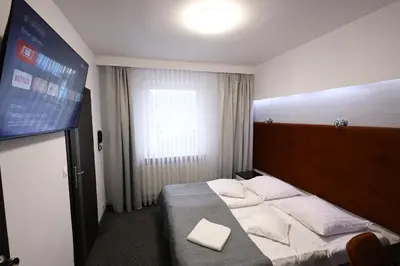 a large white building with a black roof at Kraków Garden Hotel- jesteśmy w trakcie modernizacji in Kraków