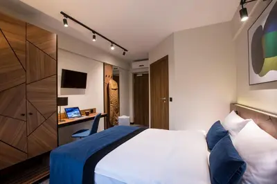 a hotel room with a bed and a desk at Ascot Premium Hotel in Kraków