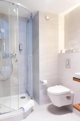 a bathroom with a toilet and a glass shower at Ascot Premium Hotel in Kraków