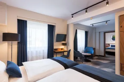 a hotel room with two beds and a television at Ascot Premium Hotel in Kraków