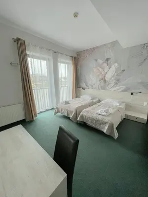a bedroom with two beds and a painting on the wall at Hotel Poleski in Kraków