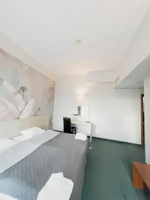 a bedroom with a large bed and a desk at Hotel Poleski in Kraków