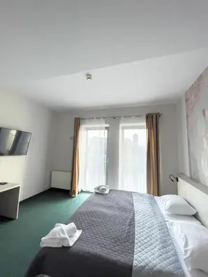 a hotel room with a bed and a window at Hotel Poleski in Kraków