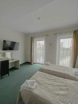 a hotel room with two beds and a flat screen tv at Hotel Poleski in Kraków