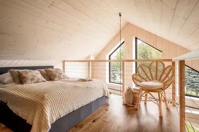a bedroom with a bed and a chair in a room at Wy_spa_Podolany in Gdów