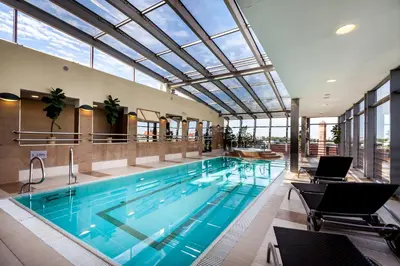 a large swimming pool in a building with a ceiling at Qubus Hotel Kraków in Kraków