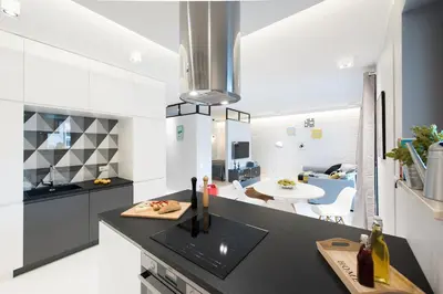 a kitchen with a black counter top and a dining room at Laurel White Apartment with Jacuzzi Bath and Pool Access in Kraków