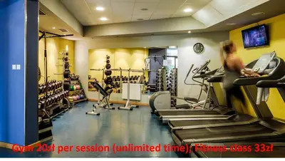 a gym with tread machines and a woman on a treadmill at Laurel White Apartment with Jacuzzi Bath and Pool Access in Kraków