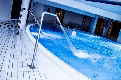 a swimming pool with a water feature in a building at Laurel White Apartment with Jacuzzi Bath and Pool Access in Kraków