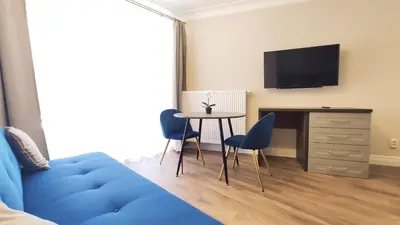 a bedroom with two beds and a blue chair at Ariańska 8A by Homeprime in Kraków