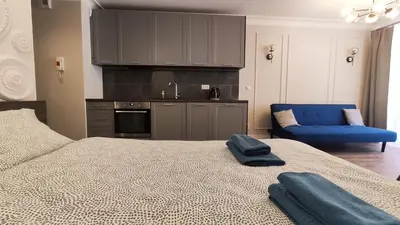 a bedroom with a bed and a kitchen with a sink at Ariańska 8A by Homeprime in Kraków