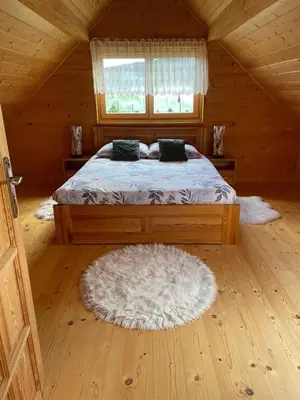 a bedroom with a bed in a wooden cabin at Dom pod Jabłonką in Stronie