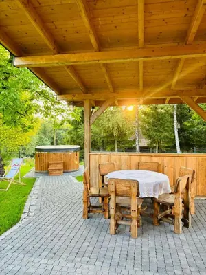 a wooden pavilion with a table and chairs on a patio at Dom pod Jabłonką in Stronie