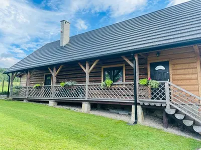 a log cabin with a porch and plants on it at Dom pod Jabłonką in Stronie