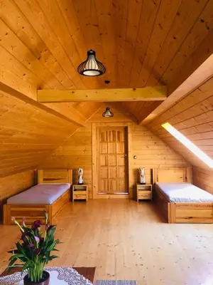 a large room with two beds in a log cabin at Dom pod Jabłonką in Stronie