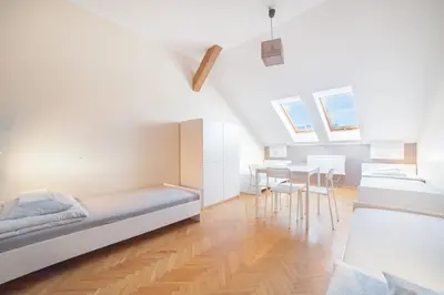 a bedroom with a bed and a dining room at Dizzy Daisy Hostel in Kraków