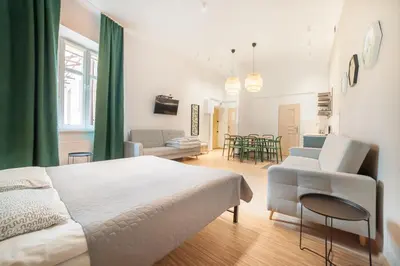 a bedroom with a bed and a living room at Dizzy Daisy Hostel in Kraków