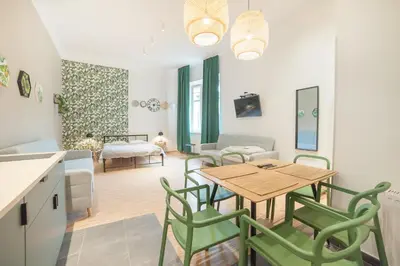 a kitchen and living room with a table and chairs at Dizzy Daisy Hostel in Kraków
