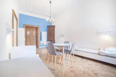 a room with a table and chairs and a bed at Dizzy Daisy Hostel in Kraków