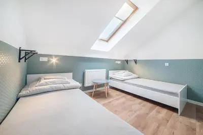 a bedroom with two beds and a table at Dizzy Daisy Hostel in Kraków