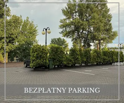 a parking lot with a row of bushes at Hotel Junior 2 in Kraków
